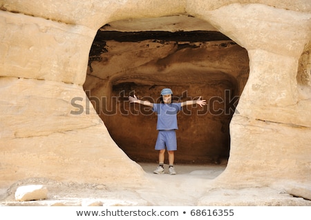 Criança turista posando no buraco da rocha Criança feliz com um boné Foto stock © Zurijeta