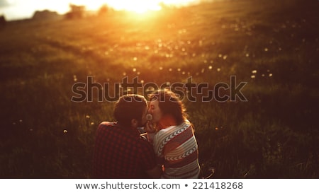 Stok fotoğraf: Couple Kissing In A Field