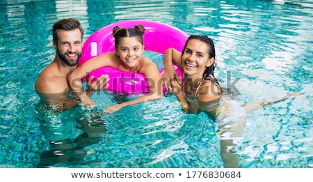 Stok fotoğraf: Excited Young Family Having Fun At The Swimming Pool