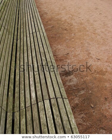 Stockfoto: Long Wooden Plank Bench On Orange Gravel