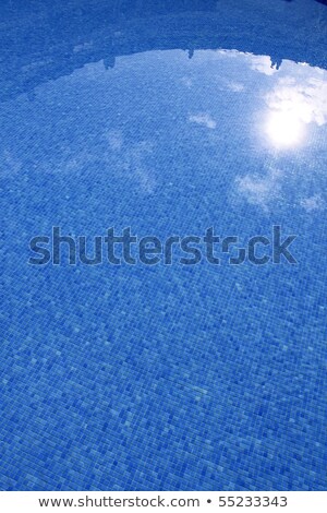 Stock photo: Blue Tiled Swimming Pool With Sun Reflexion
