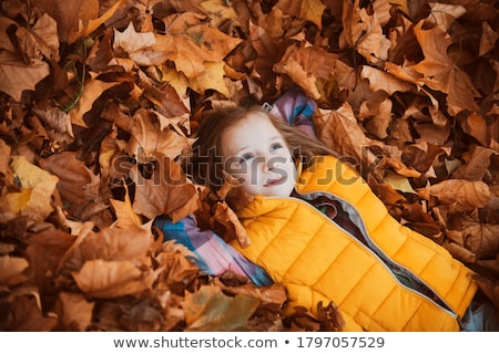 Foto stock: Girl Lying On Autumn Leaves