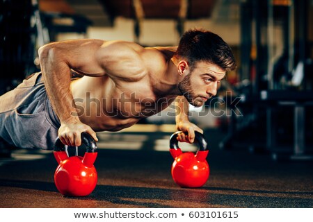 Zdjęcia stock: Muscular Man Doing Pushups With Kettlebell