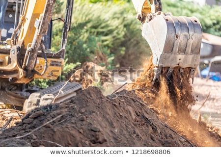 Stok fotoğraf: Working Excavator Tractor Digging A Trench At Construction Site
