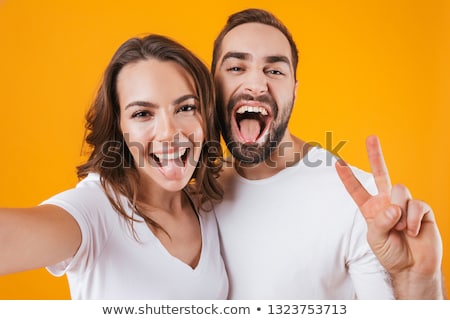 Сток-фото: Cute Young Loving Couple Posing Isolated Over Yellow Background Take A Selfie