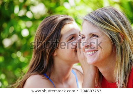 Сток-фото: Child Whispering Into Her Mothers Ear