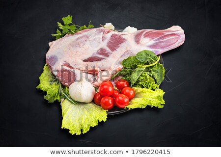 [[stock_photo]]: Fresh And Raw Meat Leg Of Lamb Uncooked Tomato And Pepper On Black Background