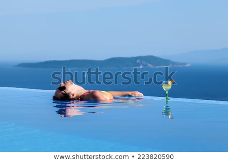 Stock fotó: Beautiful Lady Drinking A Cocktail In A Swimming Pool And Relaxi