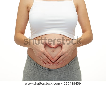 Foto stock: Close Up Of Pregnant Woman Making Heart Gesture