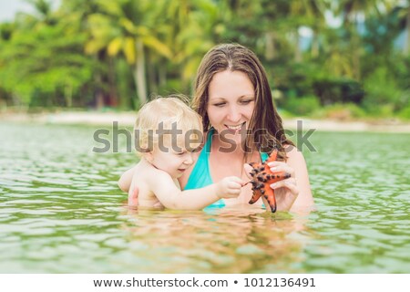 [[stock_photo]]: Mom And Son Found A Red Starfish In The Sea