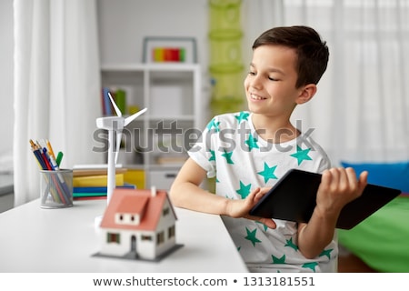 Zdjęcia stock: Boy With Tablet Toy House And Wind Turbine