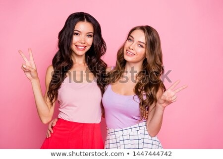 Stok fotoğraf: Portrait Of Two Multinational Women Hugging And Gesturing Peace Sign
