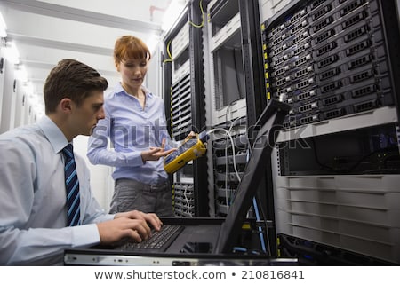 Foto stock: Team Of Technicians Using Digital Cable Analyser On Servers