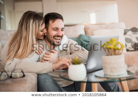 Foto d'archivio: Happy Young Couple Relaxing On The Couch With Laptop