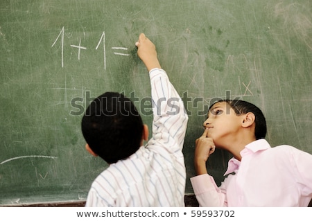 Dois meninos na sala de aula pensando, escrevendo e contando a bordo Foto stock © Zurijeta