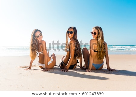 Stock fotó: Three Girls Sitting On Beach Looking Back