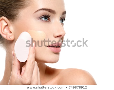 Foto d'archivio: Girl Applying Foundation On Face Isolated On White