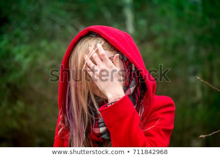 Foto stock: Scared Little Red Riding Hood Hiding In The Forest