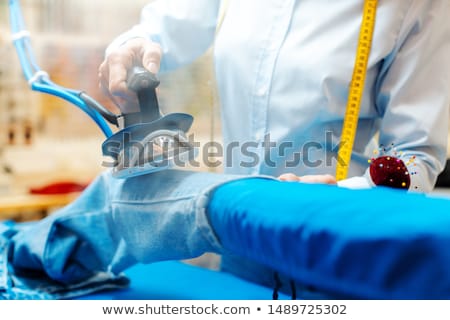 Stock photo: Employee In Textile Cleaning Ironing Some Trousers