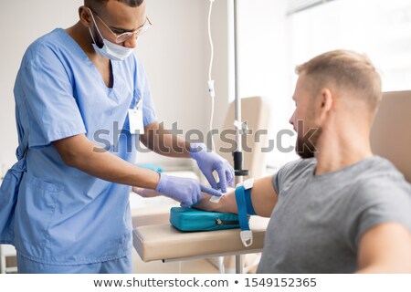 Stock photo: Contemporary Doctor Preparing Arm Of Sick Patient For Dropper Injection