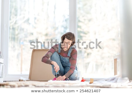 Stock foto: Caucasian Woman Using Screwdriver For Assembling Furniture