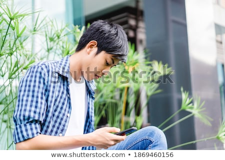 Foto stock: Young Boy Texting On Phone