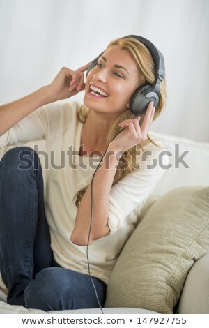 Сток-фото: Woman Listening To Mp3 Player On Headphones Relaxing Sitting On