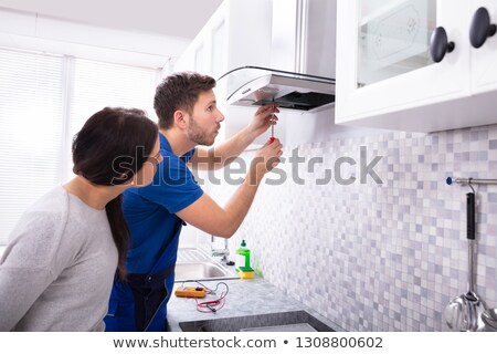 Stockfoto: Technician Fixing Extractor Filter With Screwdriver