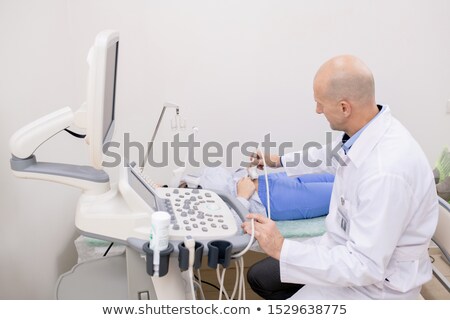 Foto stock: Experienced Doctor In Whitecoat Examining Abdominal Part Of Patient