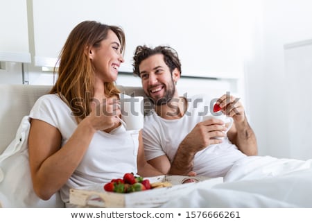 Young Beautiful Couple Eating Breakfast In Bed Zdjęcia stock © Photoroyalty