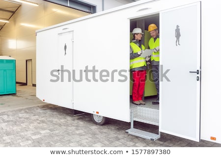 Stockfoto: Workers Inspecting A Restroom Trailer Before Renting It Out
