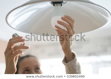 Stockfoto: Woman Changing Light Bulb