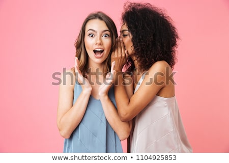 Foto stock: Two Women Whispering Into Friends Ear