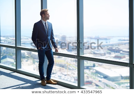 Foto stock: Stylish Young Businessman Standing Thinking