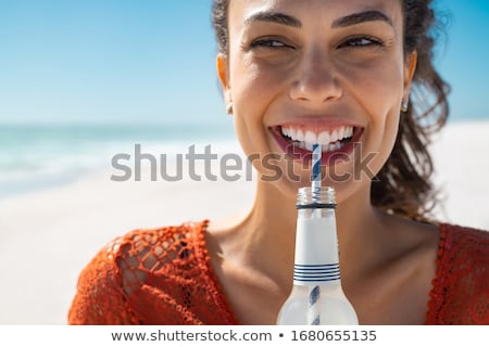 Foto stock: Close Up Of Young Women Drinking Lemonade On Beach