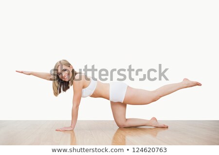 Foto stock: Portrait Of Young Woman In Yoga Pose On Hardwood Floor