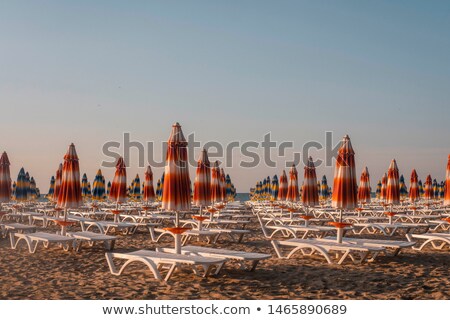 Stock photo: Reed Beach Umbrella With Loungers On Beach At Sea