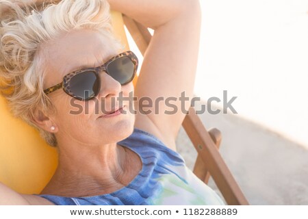 Foto d'archivio: Close Up Of Senior Woman With Sunglasses Resting On Chair