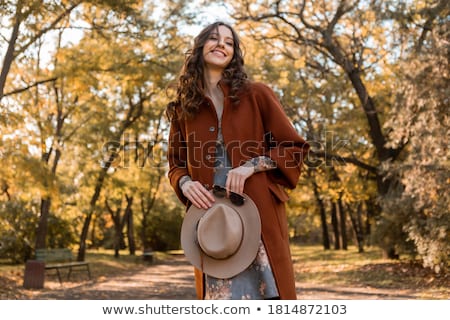 Foto d'archivio: Cheerful Young Woman Dressed In Autumn Coat And Hat