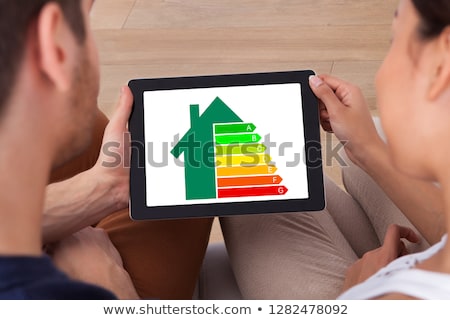 Foto d'archivio: Man Holding Cellphone With Energy Efficiency Chart On Screen