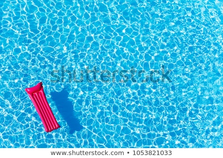 Zdjęcia stock: Pink Air Mattress Floating On Water Of Swimming Pool
