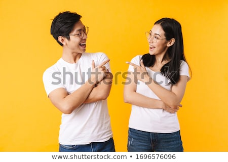 Stok fotoğraf: Asian Man Posing Isolated Over Yellow Background Pointing