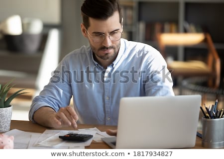 Stock fotó: Male Accountant Calculating Invoice With Calculator In Office