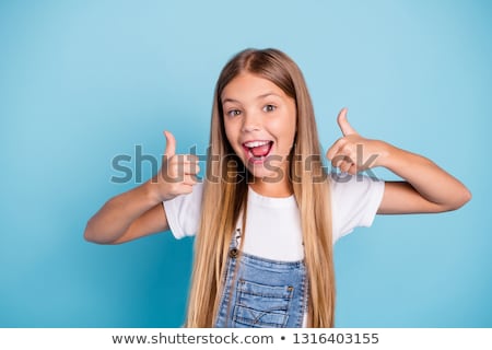 Сток-фото: Portrait Of An Excited Little Schoolgirl Showing Thumbs Up