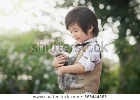 Foto d'archivio: Cute Little Boy Cuddling A Cat