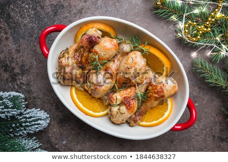 Stock foto: Baked Chicken Drumstick In A Green Dish With Orange And Rosemary