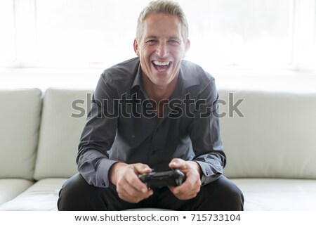 ストックフォト: Portrait Of Single 40s Man Sitting In Sofa Play Video Game