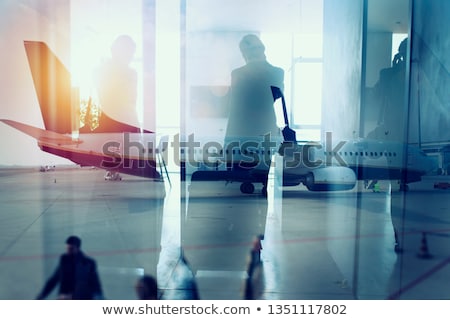 Stok fotoğraf: Silhouettes Of Businessman At The Airport Who Waits For Boarding Double Exposure