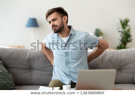 Сток-фото: Man On Sofa Suffering From Backache