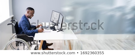 Foto stock: Disabled African Accountant Working In Wheelchair